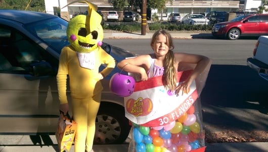image of home made halloween costumes, one a yellow papier mache FNAF costume, the other a bag of Jelly beans made with mini balloons